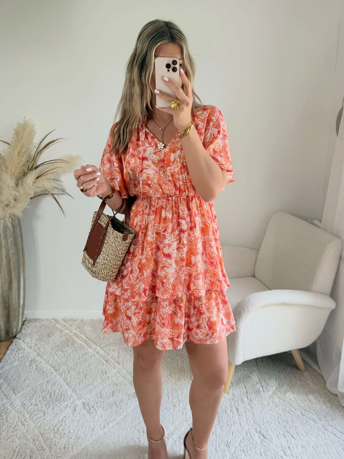 Robe corail à volants Solea, robe courte fluide à imprimé cachemire corail et rose, manches courtes évasées, taille élastiquée et jupe à volants. Modèle féminin et léger idéal pour les journées d’été.