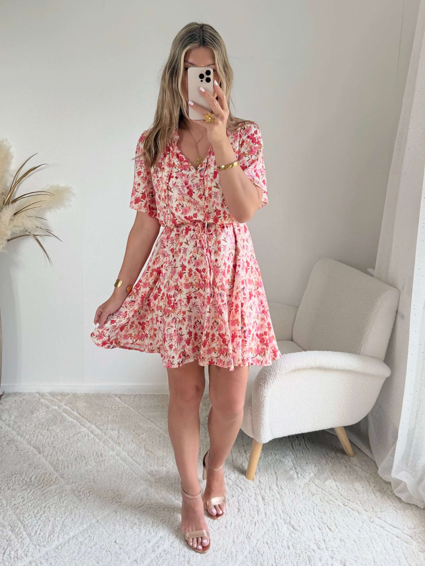 Robe courte corail fleurie Lyséa à manches courtes volantées et taille élastiquée, portée par un mannequin dans un intérieur lumineux.