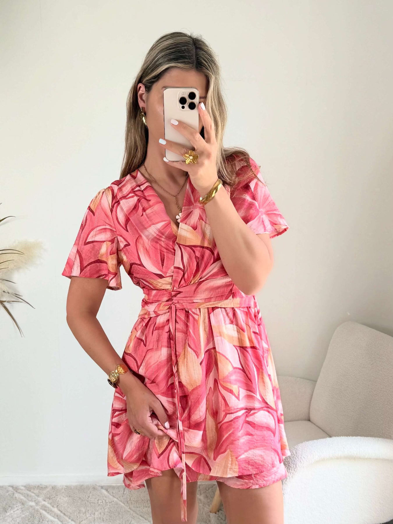 Robe Hany rose corail à imprimé floral, coupe courte fluide avec manches volantées, décolleté croisé et ceinture à nouer à la taille. Disponible du S au 4XL.