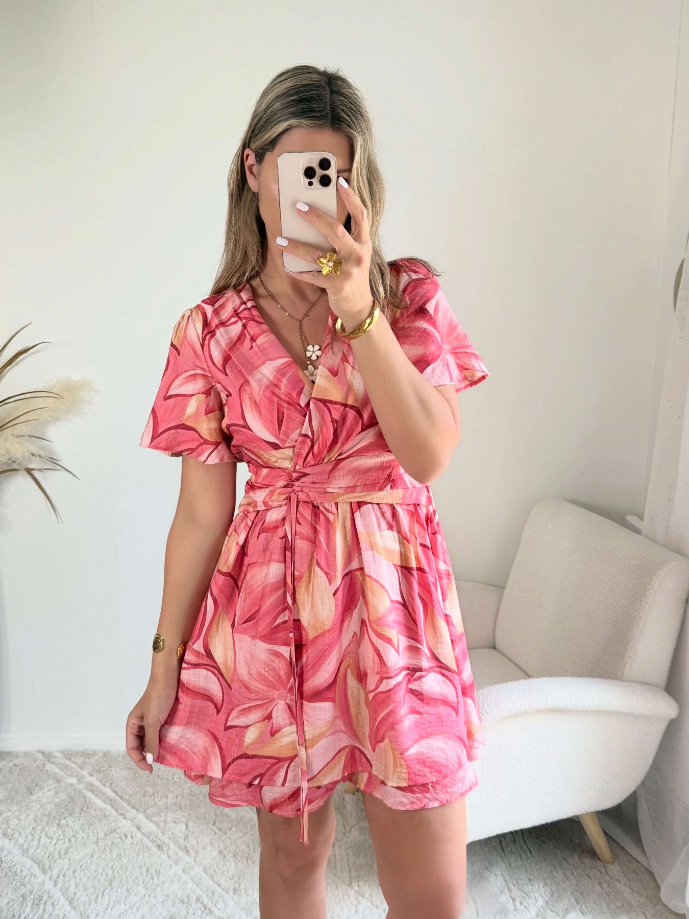 Robe Hany rose corail à imprimé floral, coupe courte fluide avec manches volantées, décolleté croisé et ceinture à nouer à la taille. Disponible du S au 4XL.