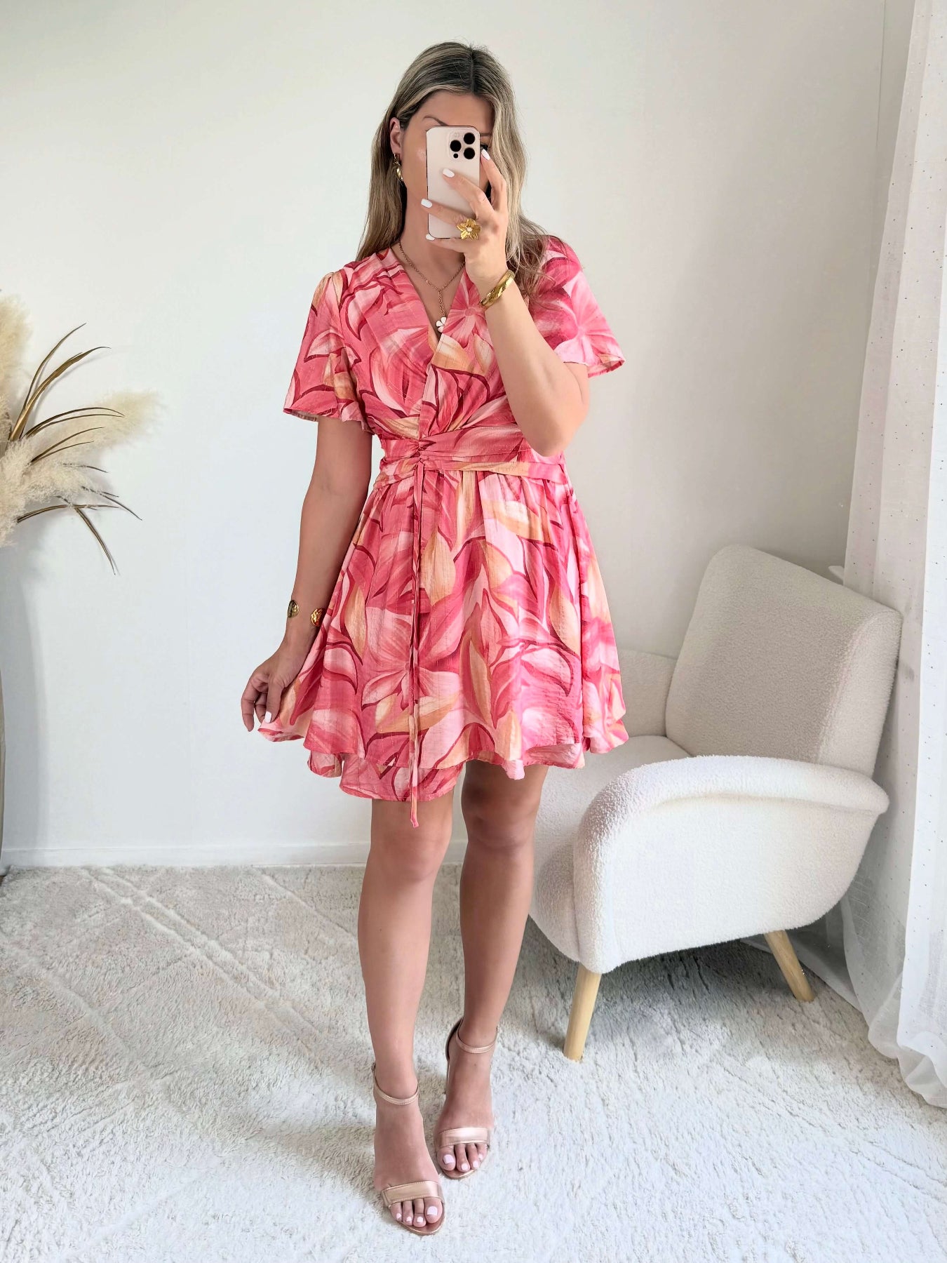 Robe Hany rose corail à imprimé floral, coupe courte fluide avec manches volantées, décolleté croisé et ceinture à nouer à la taille. Disponible du S au 4XL.
