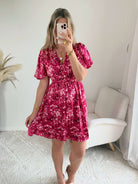 Robe courte fuchsia fleurie Guilia pour femme, coupe portefeuille, manches courtes, idéale pour les cérémonies, mariages et occasions estivales.