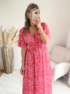 Robe longue Scarlett imprimée rose coupe fluide avec décolleté en V et manches courtes.