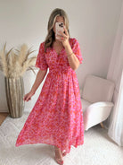 Robe longue Scarlett imprimée rose coupe fluide avec décolleté en V et manches courtes.