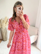 Robe longue Scarlett imprimée rose coupe fluide avec décolleté en V et manches courtes.