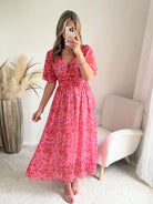 Robe longue Scarlett imprimée rose coupe fluide avec décolleté en V et manches courtes.